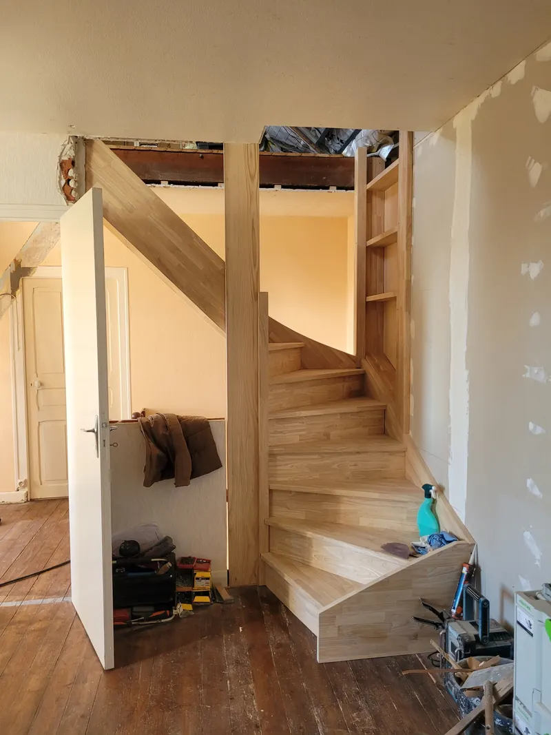 Escalier en hévéa en cours de pose, avec rangement intégré sous volée
