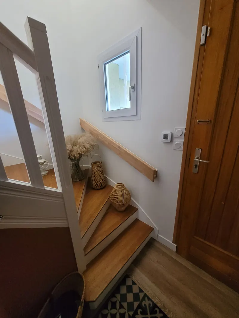 Rampe murale sur-mesure en hévéa le long d'un escalier
