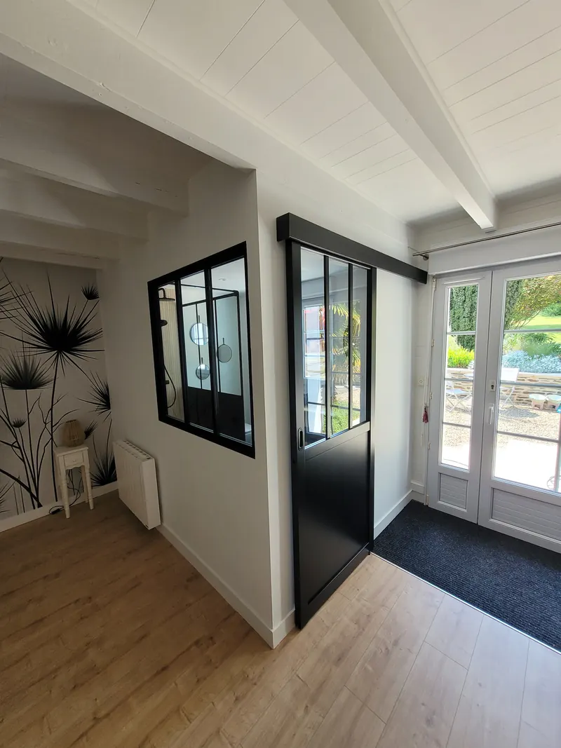 Verrière en aluminium et porte de style atelier entre deux pièces